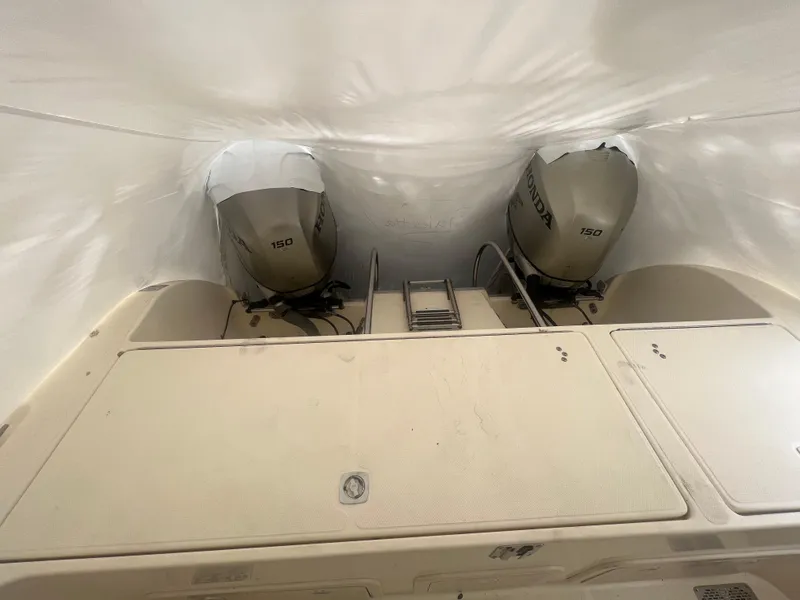 Slide: The Image of 1998 World Cat 270TE boat with twin outboard motors, covered and stored. - 31