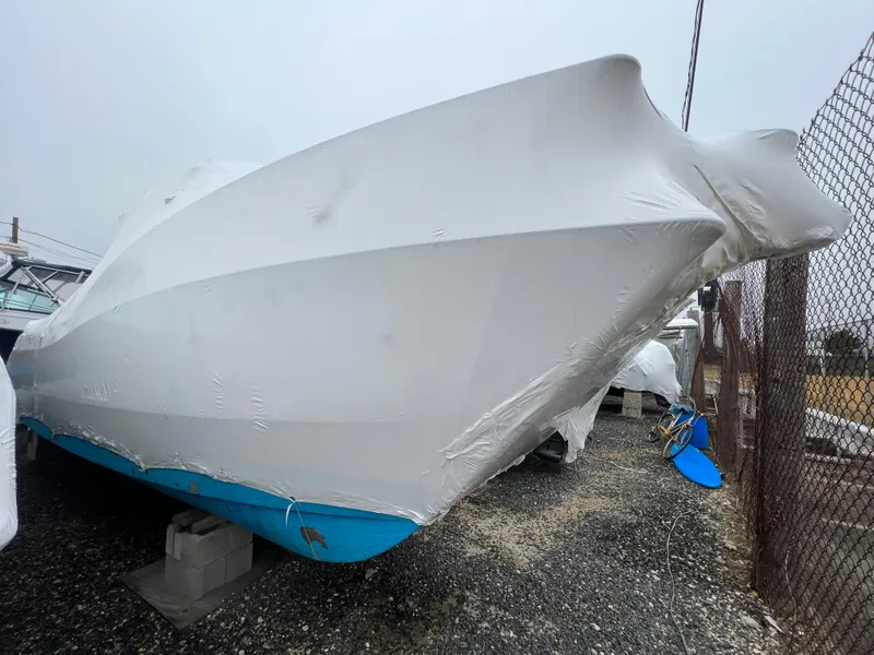 Slide: The Image of 1998 World Cat 270TE boat covered in protective wrap, stored outdoors. - 5