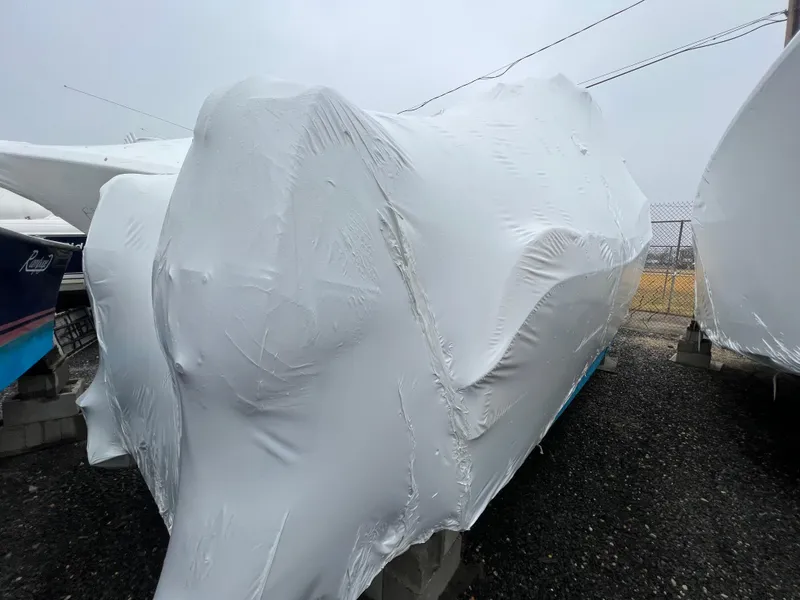 Slide: The Image of 1998 World Cat 270TE boat covered in protective white tarp, stored outdoors. - 6