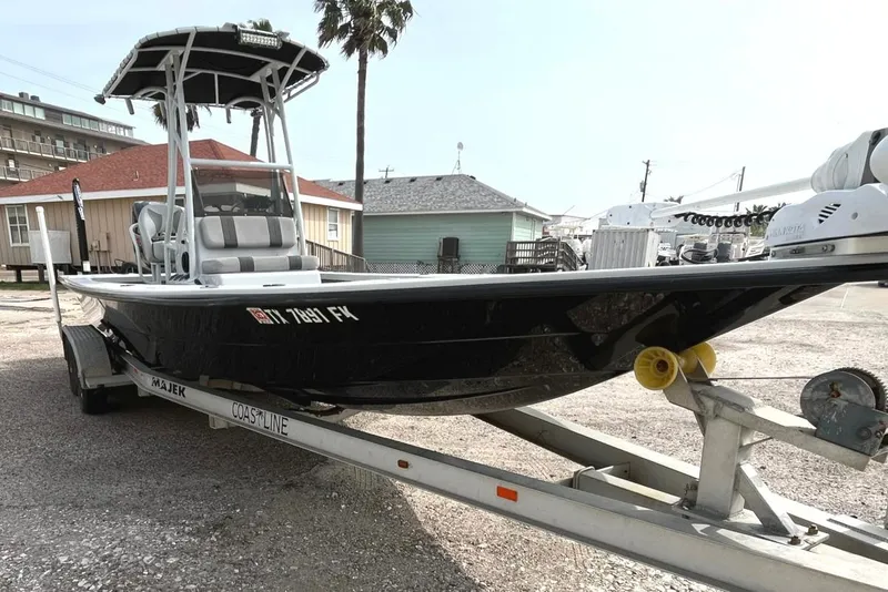 Slide: The Image of 2018 Majek 25 Extreme boat on trailer, parked near coastal homes. - 1