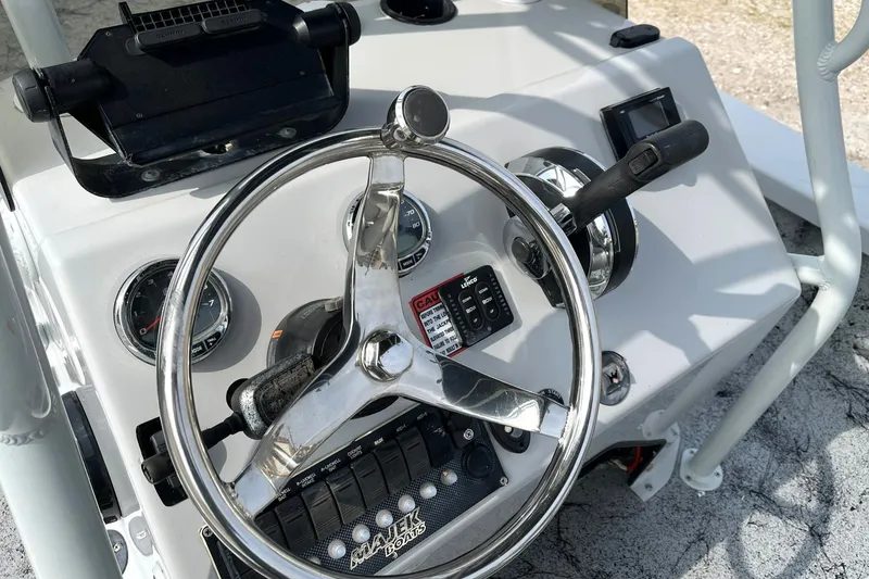 Slide: The Image of 2018 Majek 25 Extreme boat dashboard with steering wheel and controls. - 10