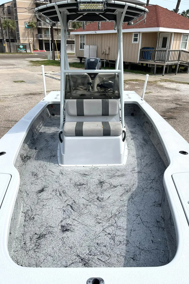 Slide: The Image of 2018 Majek 25 Extreme boat with spacious deck and seating, parked outdoors. - 6
