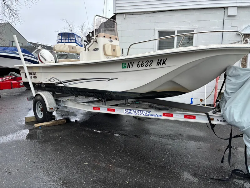 Slide: The Image of 2014 Carolina Skiff JVX18CC boat on a Venture trailer, parked outdoors. - 1