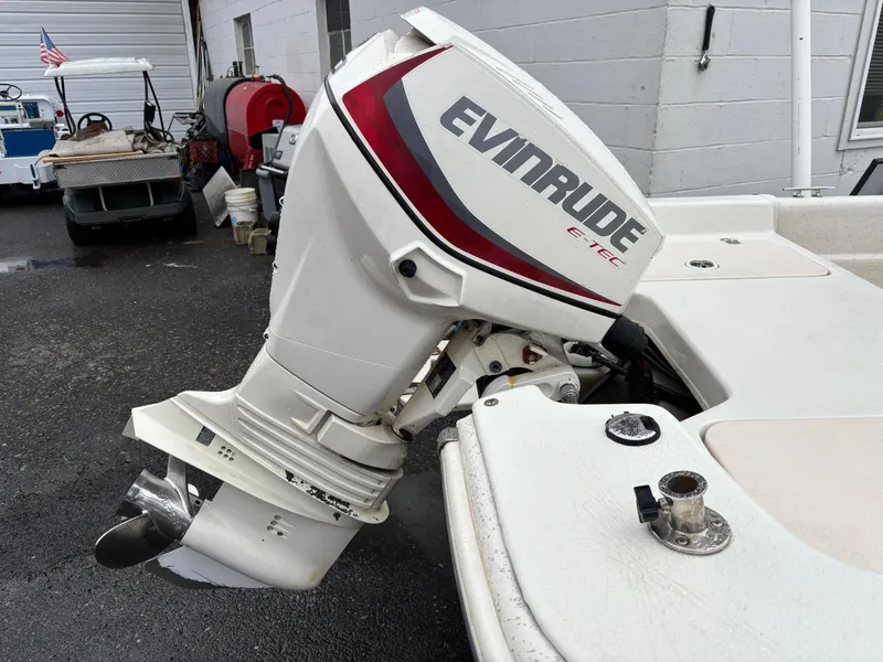 Slide: The Image of 2014 Carolina Skiff JVX18CC with Evinrude outboard motor, parked on wet pavement. - 13