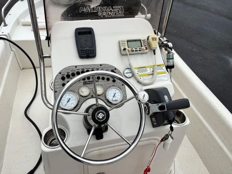 Slide: The Image of 2014 Carolina Skiff JVX18CC boat console with steering wheel, gauges, and communication devices. - 3