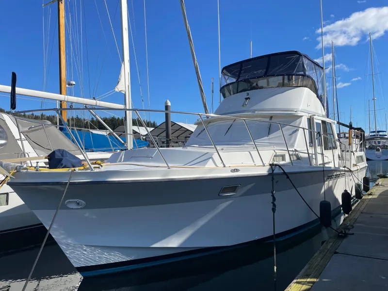 The Image of 1971 Uniflite 42 DC yacht docked at marina under clear blue sky. - 0