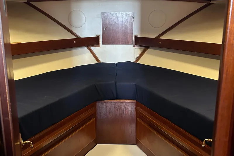 Slide: The Image of 1971 Uniflite 42 DC cabin interior with dark cushions and wooden storage. - 10