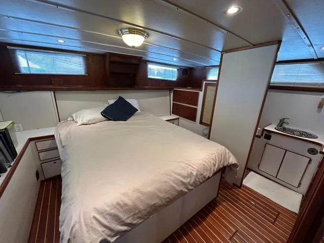 Slide: The Image of 1971 Uniflite 42 DC yacht bedroom with wood flooring and cozy bed. - 13