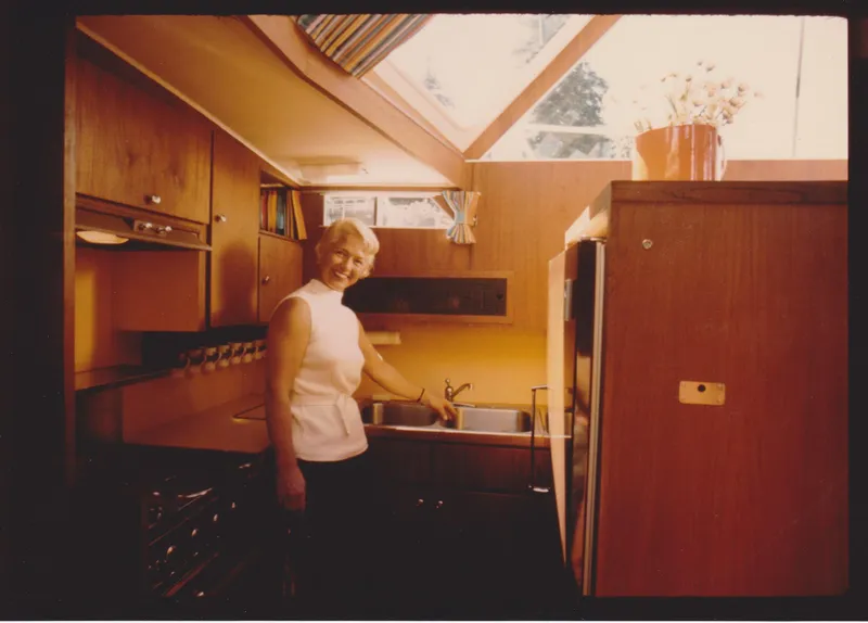 Slide: The Image of 1971 Uniflite 42 DC yacht kitchen with a person by the sink, under skylight. - 15