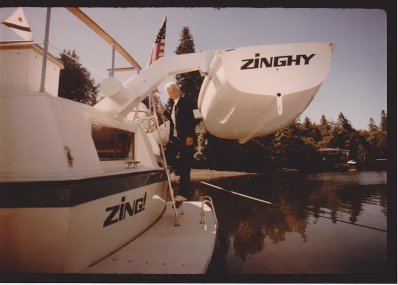 Slide: The Image of 1971 Uniflite 42 DC boat with "Zinghy" dinghy, docked on a calm lake. - 17