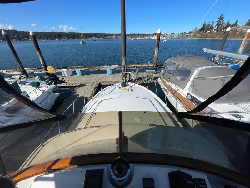 Slide: The Image of 1971 Uniflite 42 DC yacht docked at marina, clear blue sky, scenic waterfront view. - 7