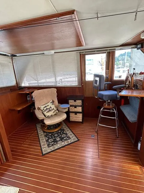 Slide: The Image of 1971 Uniflite 42 DC interior with wood flooring, cozy seating, and nautical decor. - 9