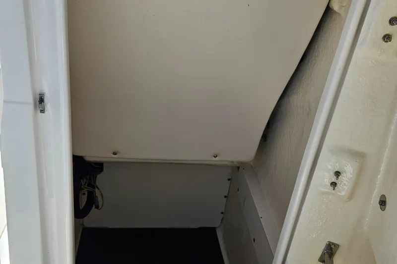 Slide: The Image of Storage compartment inside a 2017 Robalo 222 boat, featuring a clean, white interior. - 24