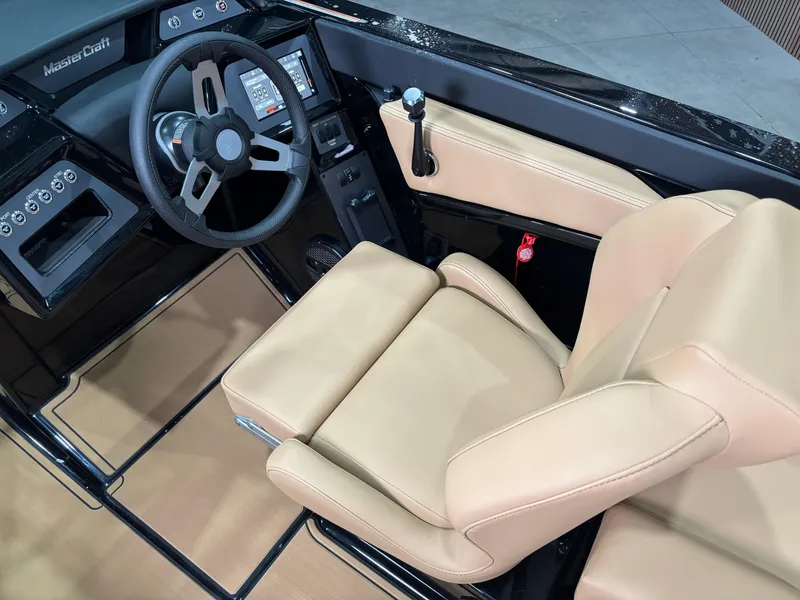 Slide: The Image of 2025 MasterCraft NXT22 boat interior with beige seating and modern dashboard. - 10