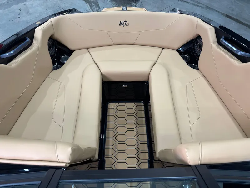 Slide: The Image of 2025 MasterCraft NXT22 boat interior with beige seating and hexagonal floor design. - 11