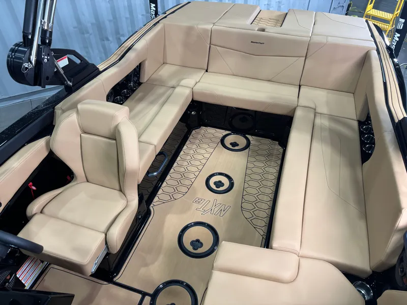 Slide: The Image of 2025 MasterCraft NXT22 boat interior with beige seating and modern design. - 12