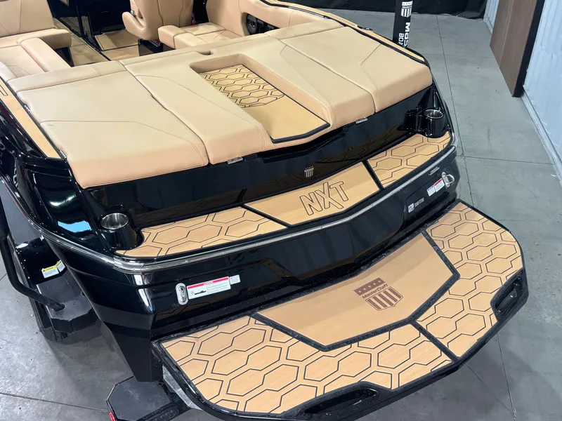 Slide: The Image of 2025 MasterCraft NXT22 boat with tan upholstery and hexagonal pattern detailing. - 5