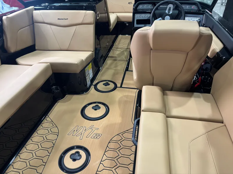 Slide: The Image of 2025 MasterCraft NXT22 interior with beige seating and modern dashboard design. - 9