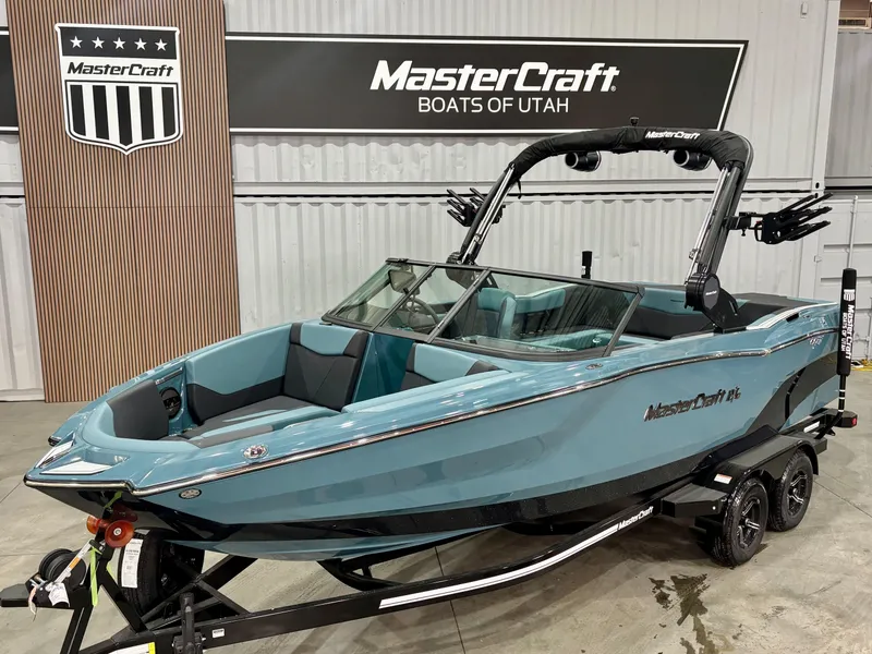 The Image of 2025 MasterCraft NXT23 boat in showroom, blue exterior, displayed at MasterCraft Boats of Utah. - 1