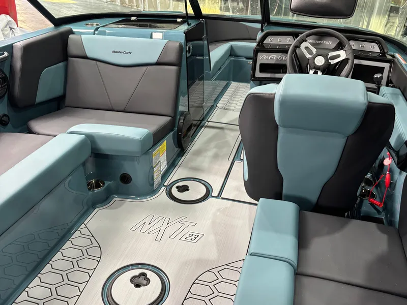 Slide: The Image of 2025 MasterCraft NXT23 boat interior with modern seating and steering wheel. - 10