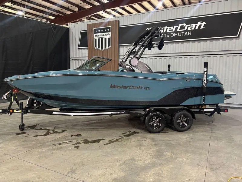 Slide: The Image of 2025 MasterCraft NXT23 boat in showroom, teal color, on trailer. - 3