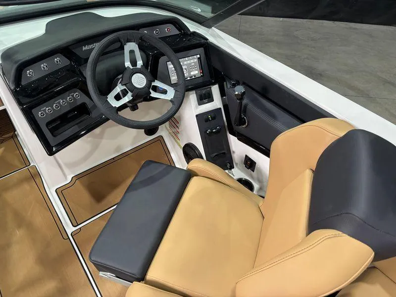 Slide: The Image of 2025 MasterCraft NXT24 boat interior with tan seating and modern dashboard controls. - 10
