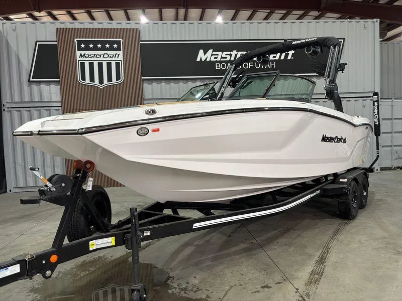 Slide: The Image of 2025 MasterCraft NXT24 boat on trailer in showroom setting. - 3