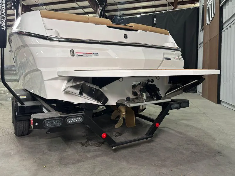 Slide: The Image of 2025 MasterCraft NXT24 boat rear view in a warehouse setting. - 7