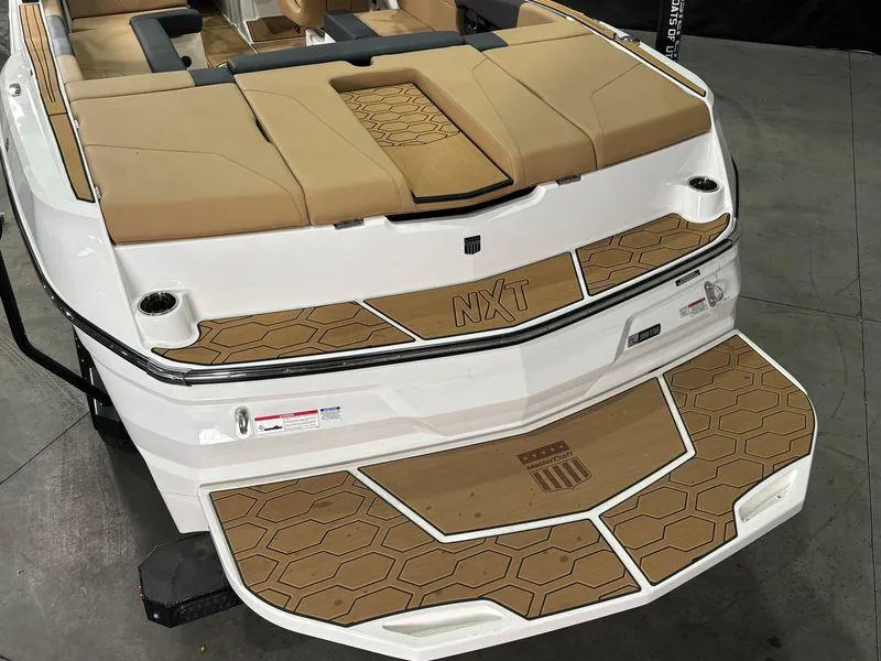 Slide: The Image of 2025 MasterCraft NXT24 boat with tan seating and hexagonal deck design. - 8