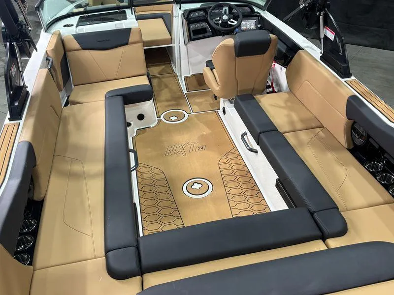 Slide: The Image of 2025 MasterCraft NXT24 boat interior with tan and black seating, modern dashboard, and spacious layout. - 9