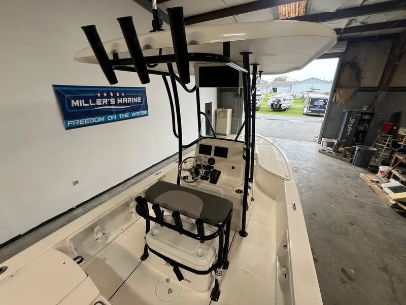 Slide: The Image of 2024 Sea Born FX 21 BAY boat interior with steering console in a showroom. - 2