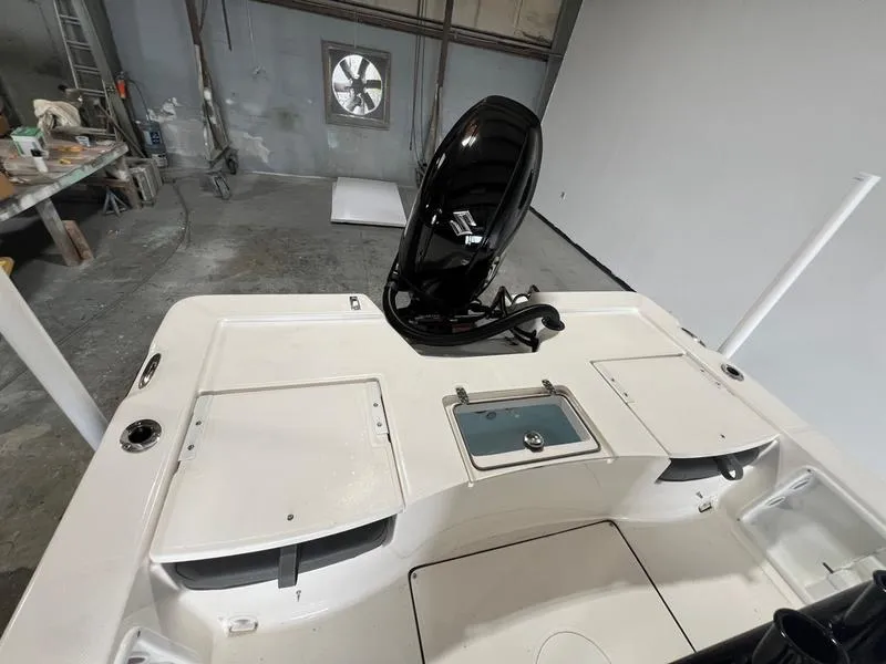 Slide: The Image of 2024 Sea Born FX 21 BAY boat interior with motor in a workshop setting. - 4