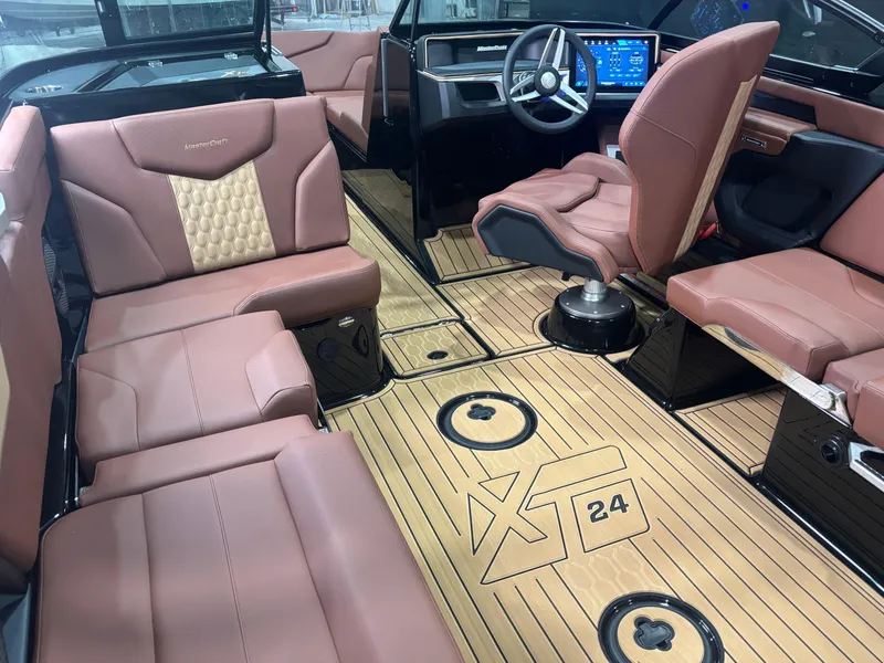 Slide: The Image of 2025 MasterCraft XT24 boat interior with luxurious brown leather seating and modern dashboard. - 11