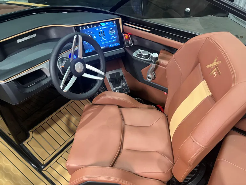 Slide: The Image of 2025 MasterCraft XT24 boat interior with advanced dashboard and luxurious seating. - 13