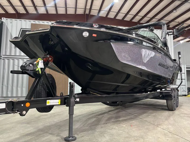 Slide: The Image of 2025 MasterCraft XT24 boat on trailer in indoor storage facility. - 2
