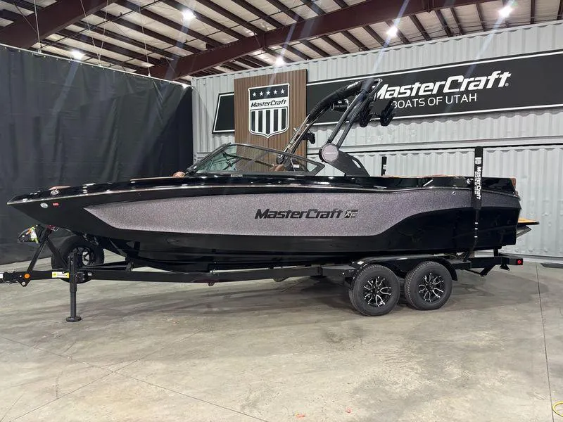 Slide: The Image of 2025 MasterCraft XT24 boat displayed indoors on a trailer. - 3