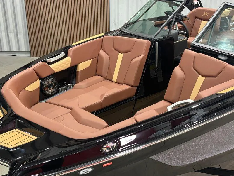 Slide: The Image of 2025 MasterCraft XT24 boat interior with luxurious brown seating and sleek design. - 5