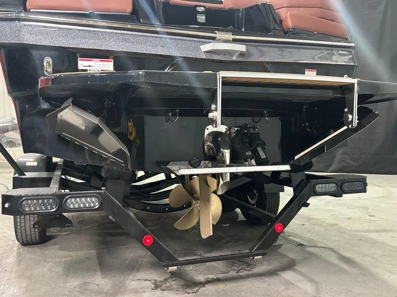 Slide: The Image of 2025 MasterCraft XT24 boat stern with propeller and trailer in a showroom. - 6