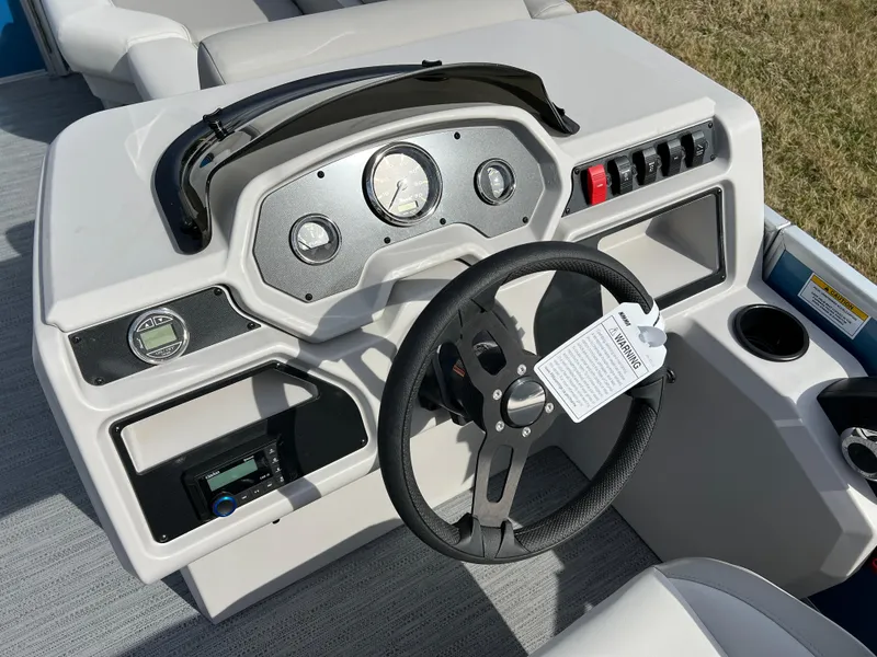 Slide: The Image of 2025 Godfrey Xperience Split Bench boat dashboard with steering wheel and control panel. - 17
