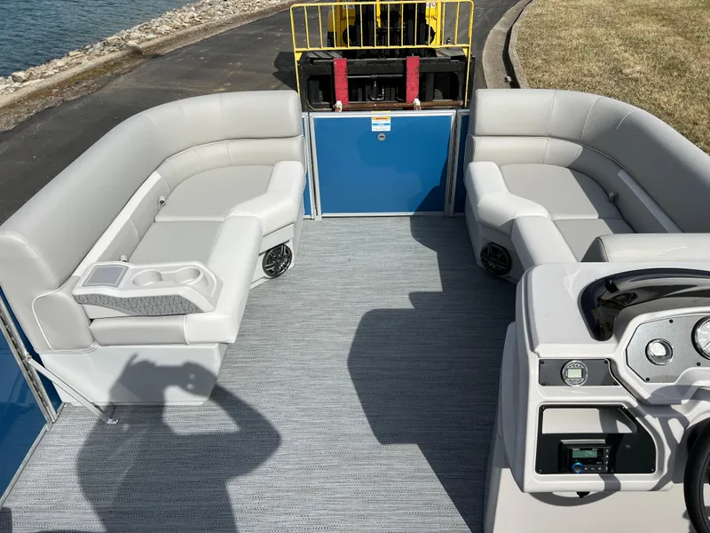 Slide: The Image of 2025 Godfrey Xperience Split Bench boat interior with gray seating and blue accents. - 18