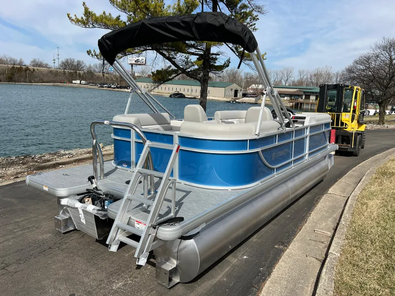 Slide: The Image of 2025 Godfrey Xperience Split Bench pontoon boat by a lakeside with a canopy. - 4