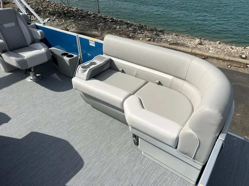 Slide: The Image of 2025 Godfrey Xperience Split Bench on boat, featuring sleek gray upholstery by the water. - 9