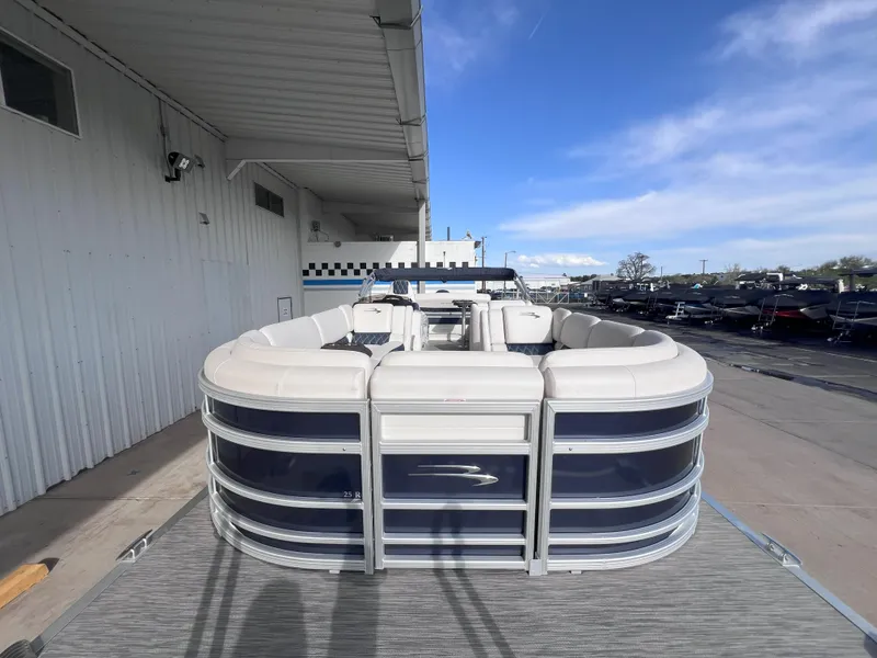 Slide: The Image of 2022 Bennington 25RSB pontoon boat docked under a clear blue sky. - 2