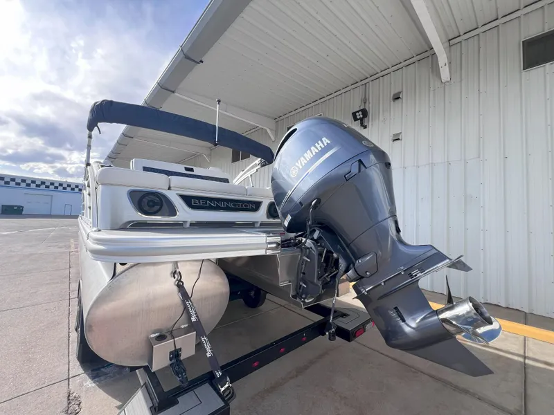 Slide: The Image of 2022 Bennington 25RSB pontoon boat with Yamaha outboard motor, parked near a building. - 6