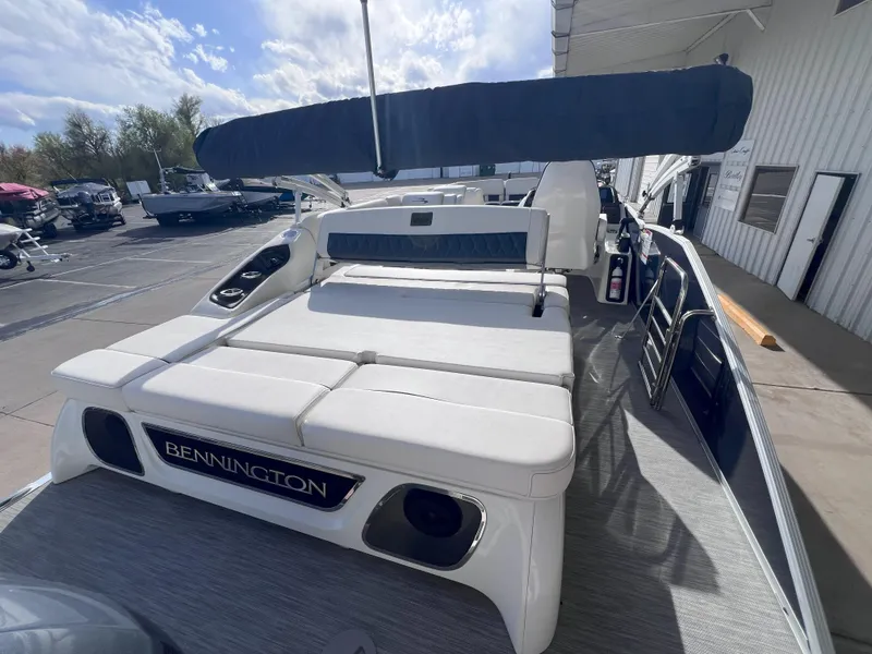 Slide: The Image of 2022 Bennington 25RSB pontoon boat with sunshade, docked outdoors under a partly cloudy sky. - 7
