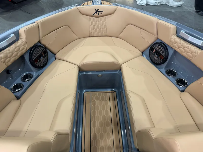 Slide: The Image of 2025 MasterCraft XT23 boat interior with tan upholstery and modern design. - 11