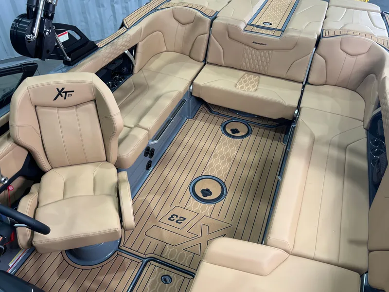 Slide: The Image of Luxurious interior of 2025 MasterCraft XT23 boat with tan leather seating and wood flooring. - 12