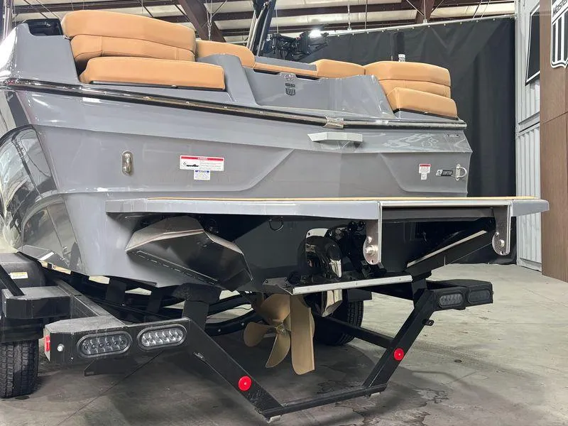 Slide: The Image of 2025 MasterCraft XT23 boat rear view in a warehouse setting. - 6