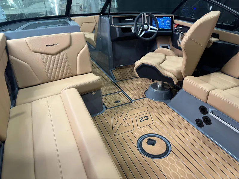 Slide: The Image of 2025 MasterCraft XT23 interior with tan leather seats and modern dashboard. - 7