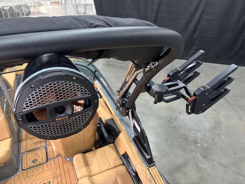 Slide: The Image of 2025 MasterCraft XT23 boat with speaker and wakeboard rack, featuring tan interior. - 8